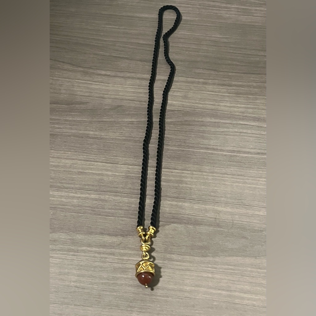 Black Twisted Cord Necklace With Gold Embellishments And Rust Colored Stone